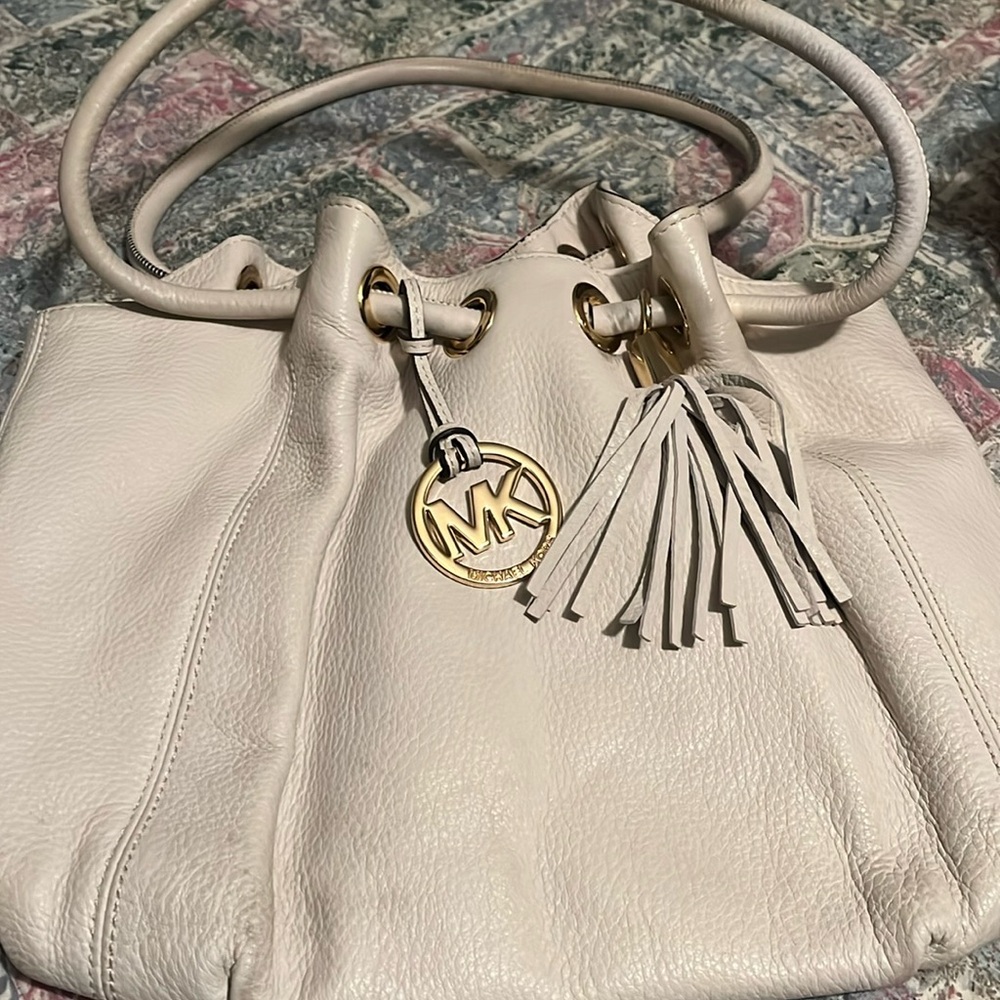 White handbag with one good size zipper pocket and 4 open pockets.